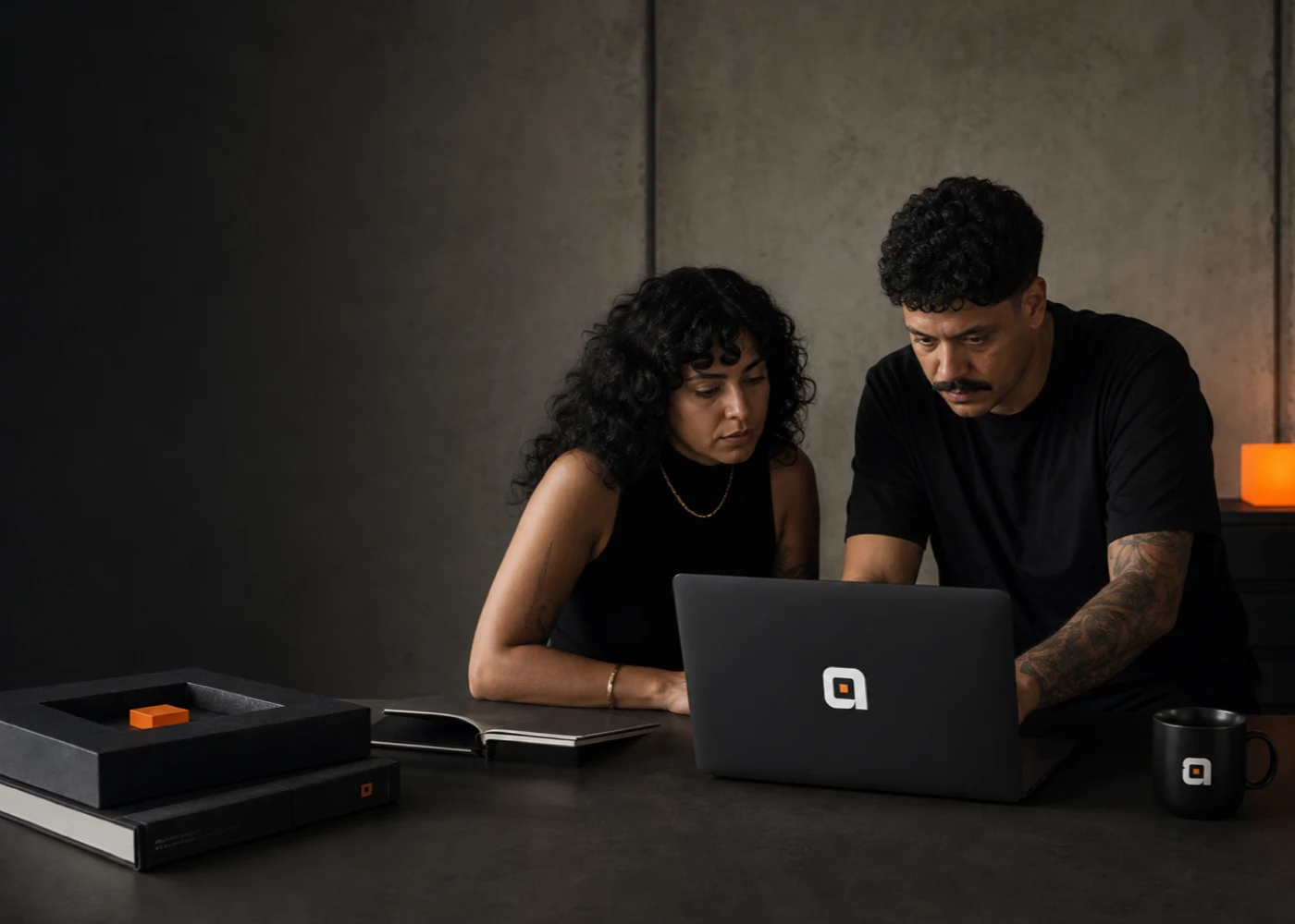 Duas pessoas brasileiras ficcionais colaborando diante de um laptop